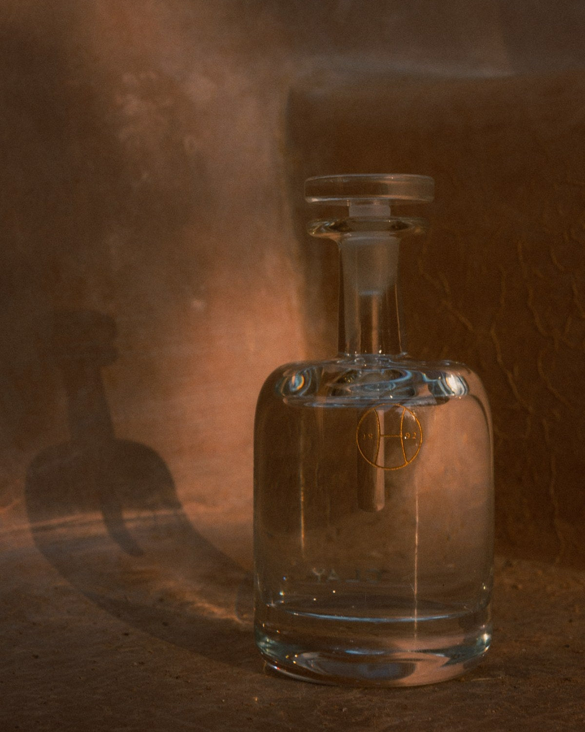Clay hand blown bottle against an ochre wall